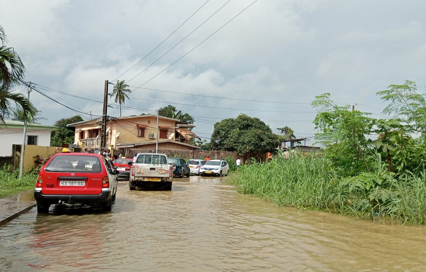 Ici plusieurs véhicules à la peine pour traverser cette piscine de fortune   qui s'est formée au beau milieu de la chaussée après la pluie.