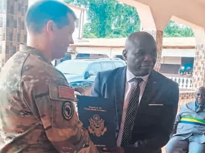 Geste symbolique de réception entre l’attaché de Défense américain, Christopher Plume et le DG de Bongolo, Rev. pasteur Benjamin Kombo