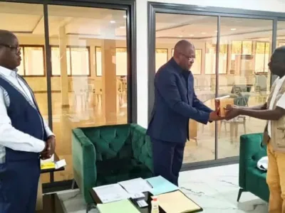 Le responsable local de lutte contre le VIH/Sida remet symboliquement un lot de préservatifs au gouverneur de province.