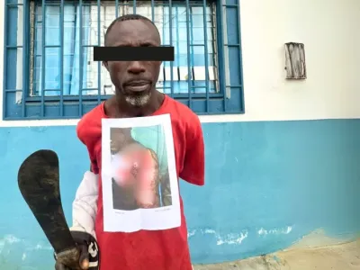 Le Ghanéen Isaak Ousmane tenant son arme blanche.