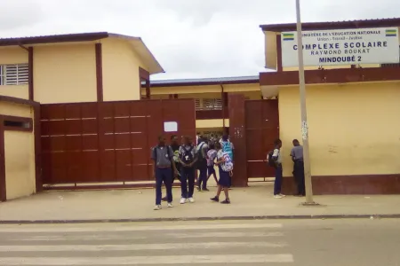 Des élèves debout devant Le lycée Raymond Bouka © DR