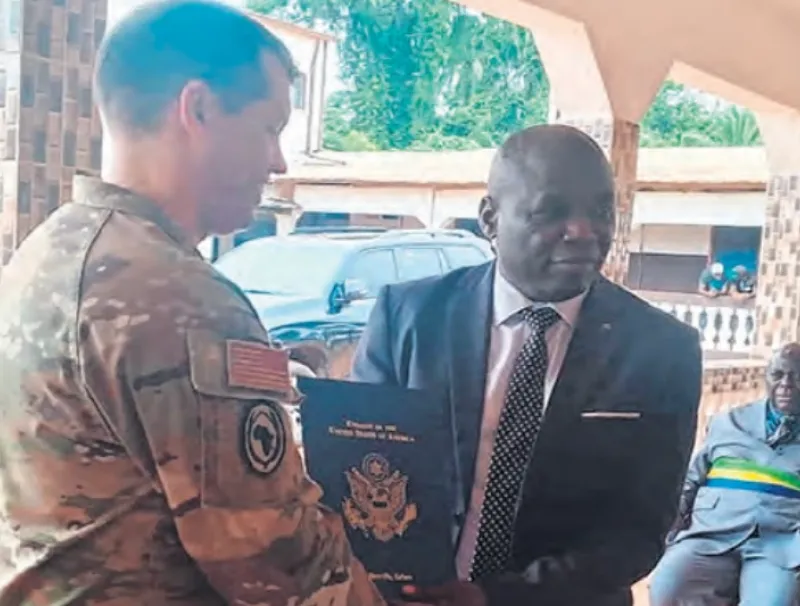 Geste symbolique de réception entre l’attaché de Défense américain, Christopher Plume et le DG de Bongolo, Rev. pasteur Benjamin Kombo