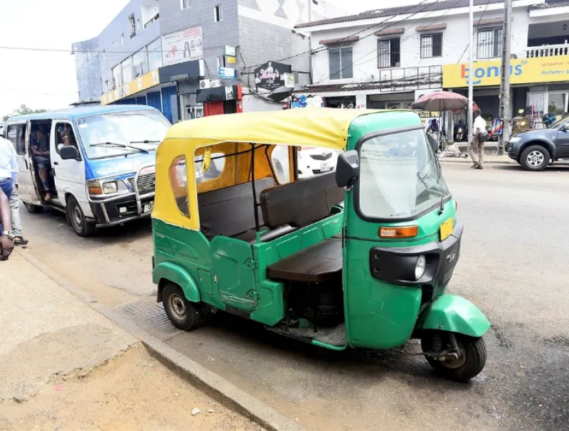 Un Tricycle disputant la chaussée avec des taxis traditionnels au niveau d’Awendjé. © Jocelyn Abila