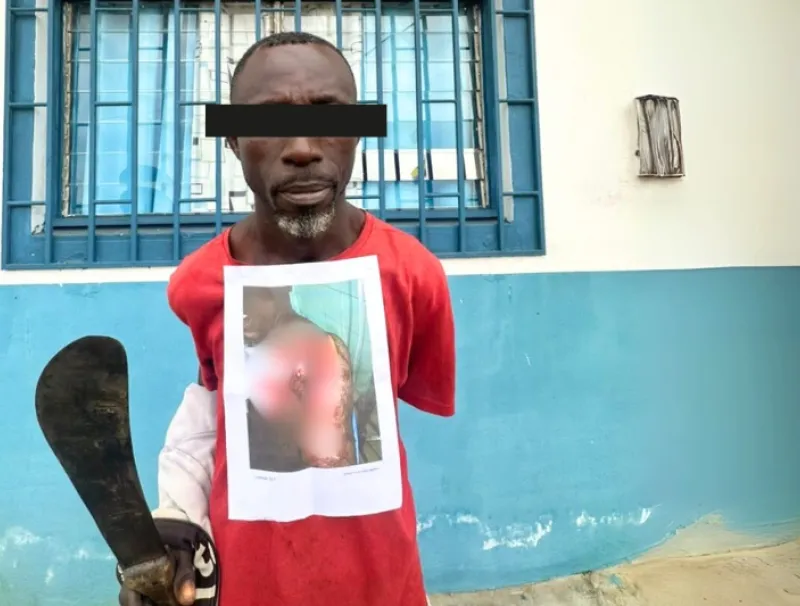 Le Ghanéen Isaak Ousmane tenant son arme blanche.