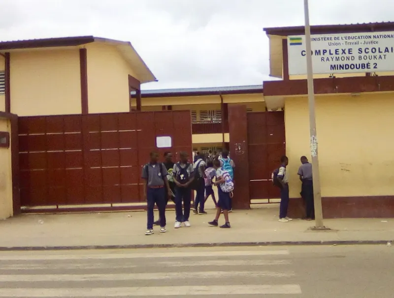 Des élèves debout devant Le lycée Raymond Bouka © DR